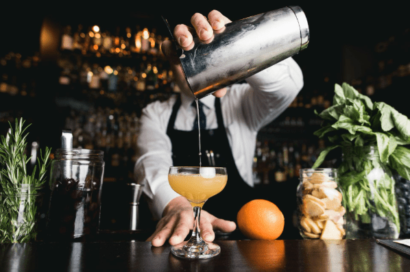 Un bartender expert en pleine préparation d’un cocktail raffiné, mêlant créativité et savoir-faire pour offrir une expérience gustative unique. Notre service de bar à cocktails apporte une touche d’élégance et de festivité à chaque événement, avec des boissons savoureuses et une présentation soignée.